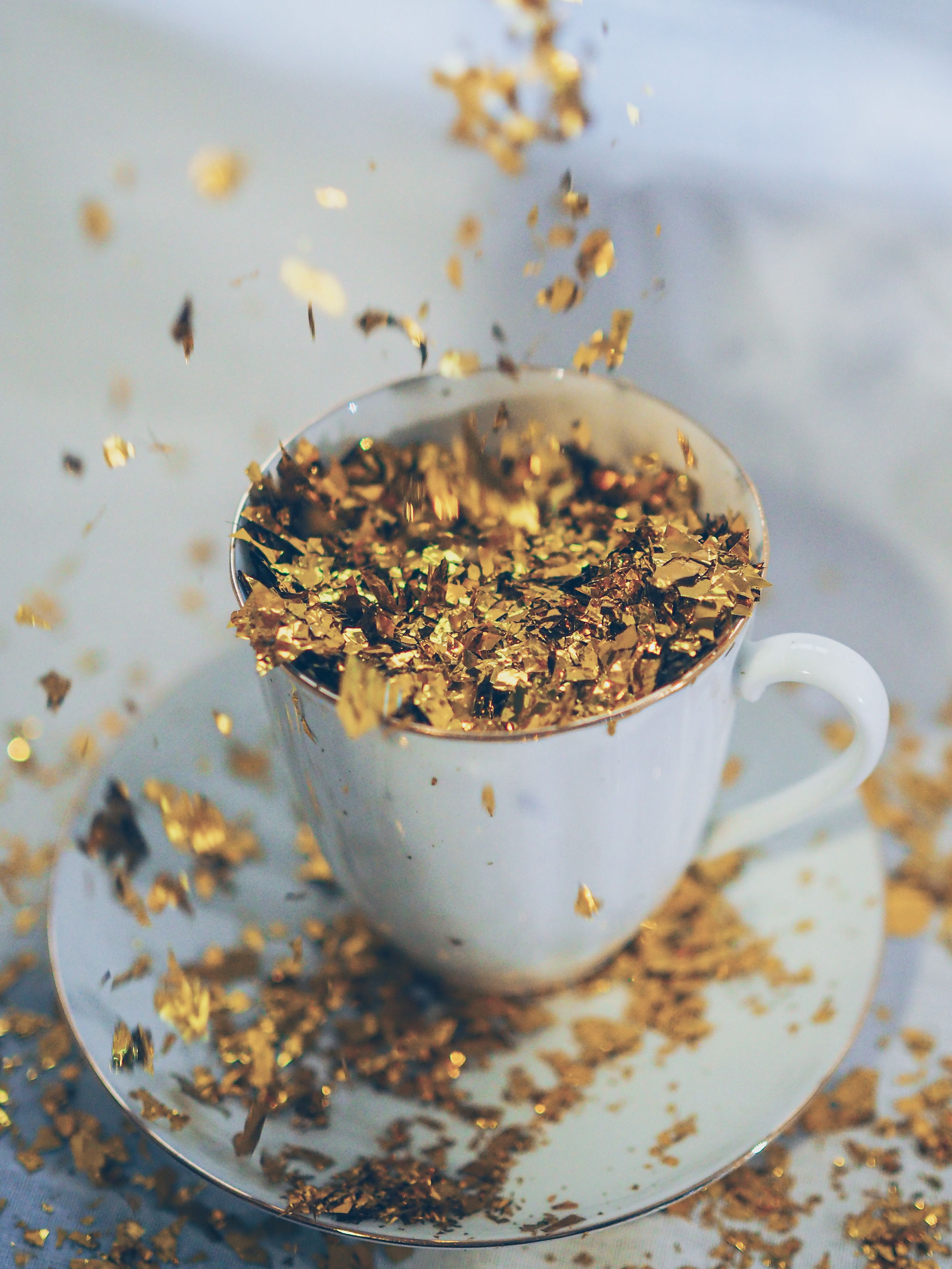 Gold glitter overflowing a teacup